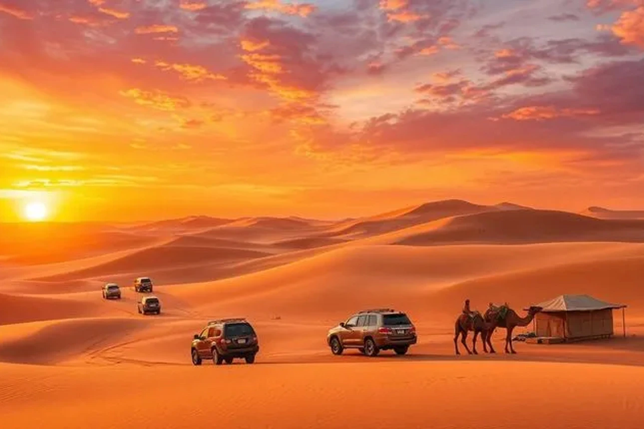 A 4x4 vehicle driving over sand dunes in a desert.